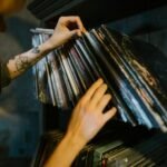 close up of woman looking through records on a shelf