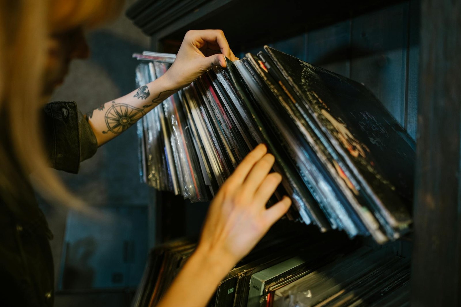 close up of woman looking through records on a shelf