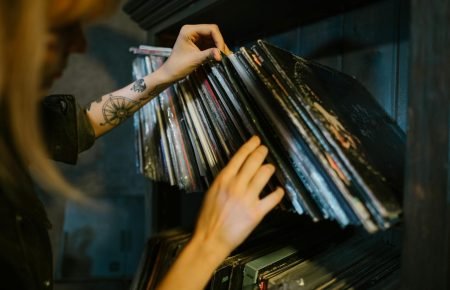 close up of woman looking through records on a shelf